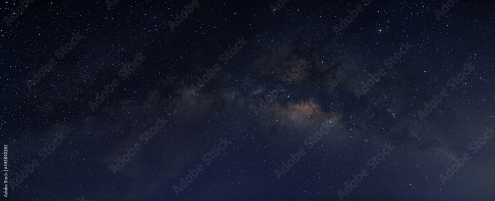 Milky way in the night sky and stars on dark background with noise and grain. Photo taken with long exposure and white balance selected.