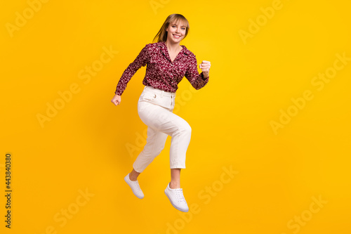 Full length body size photo jumping woman smiling running fast isolated bright yellow color background