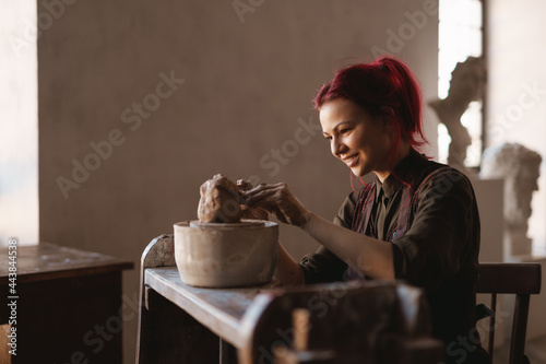 Young woman sculptor artist creating a bust sculpture