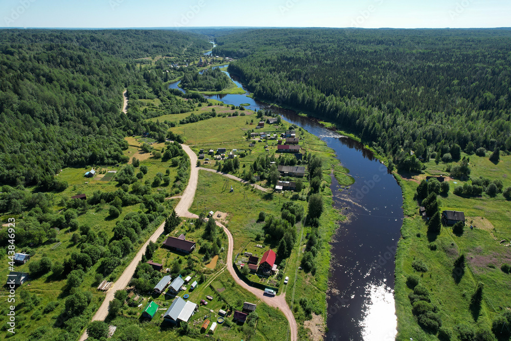 aerial view river flowing village by the river in the middle of the forest river bend houses and agricultural field