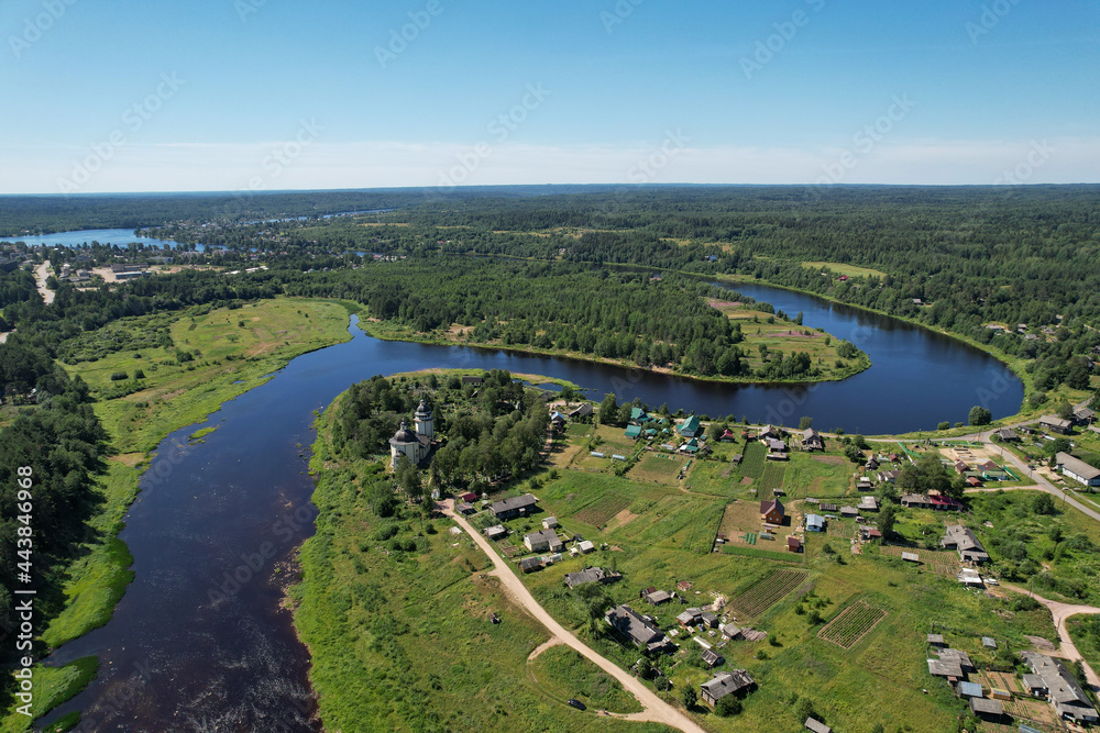aerial view the river flows the village on the bank of the river in the middle of the forest the bend of the river church on the bank of the river flowing into another
