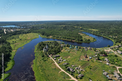 aerial view the river flows the village on the bank of the river in the middle of the forest the bend of the river church on the bank of the river flowing into another