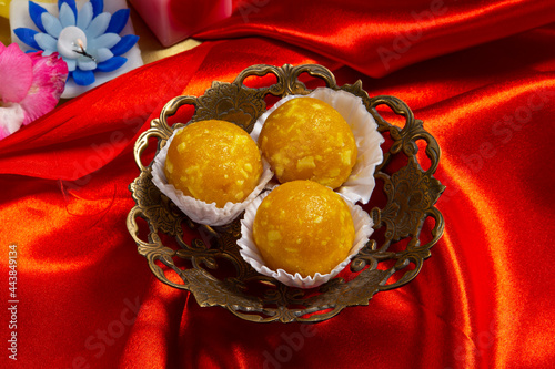 Indian sweets in a plate includes Gulab Jamun, Rasgulla, kaju katli, morichoor / Bundi Laddu, Gujiya or Karanji for diwali celebration photo