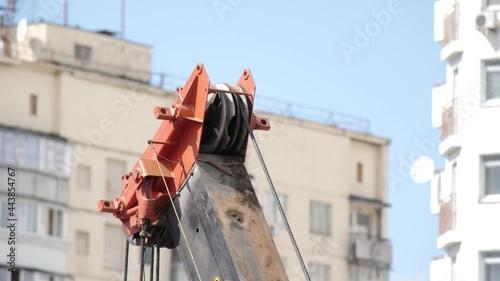 Tower Crane Hoist Rope against the blue sky and high building. Hawser of crane winch. Hoist Rope of Building crane. Crane lifting cables. Builder equipment on a construction site. Close Up.