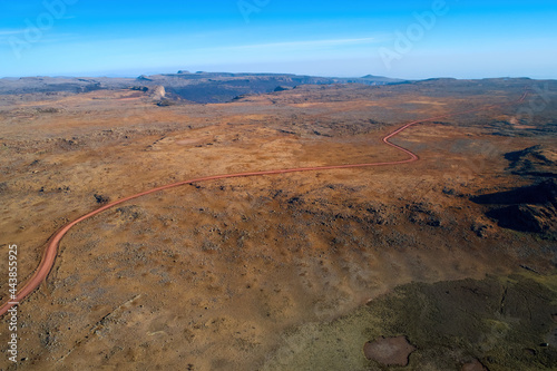 Aerial view of a dirt road crossing the strange, inhospitable landscape of the Sanetti plateau. Mars landscape in Bale mountains national park, home of rare animals. Travel around Ethiopia.