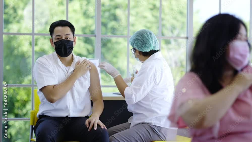 COVID-19 Vaccination station. Doctor or nurse are vaccinating man patient protect COVID-19 or flu in hospital room. People wear face mask protection from virus disease at clinic or hospital office COVID-19 Vaccination station. Doctor or nurse are vaccinating man patient protect COVID-19 or flu in hospital room. People wear face mask protection from virus disease at clinic or hospital office