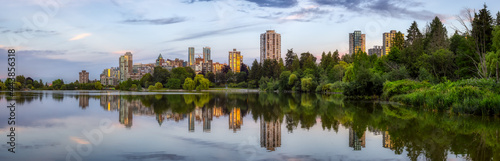 Panoramic View of Lost Lagoon in famous Stanley Park in a modern city with buildings skyline in background. Colorful Sunset Sky. Downtown Vancouver, British Columbia, Canada. © edb3_16