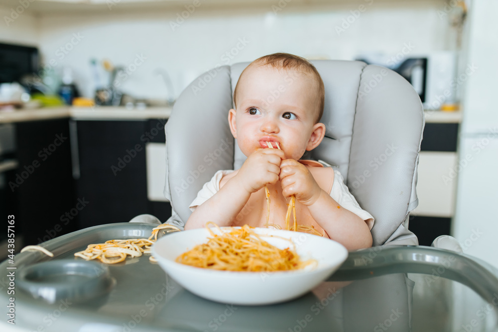 little Boy eating spaghetti look hungry and pasta sauce messes all
