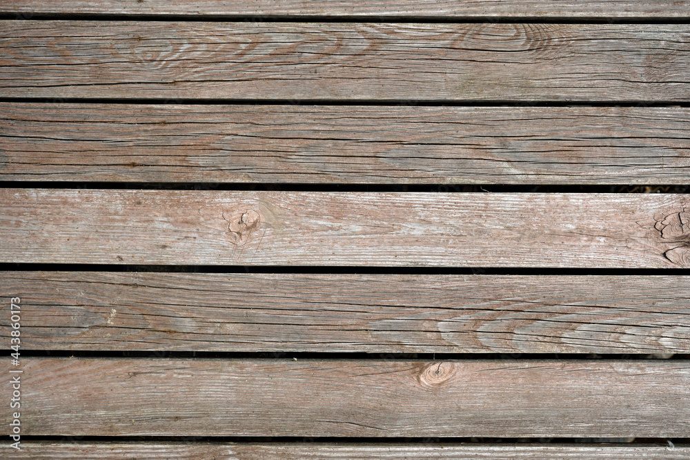 The texture of natural materials. Boardwalk pier on the river bank in the rain and sun