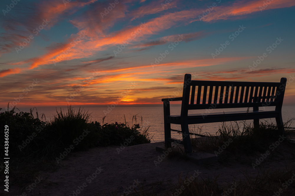 Sonnenuntergang an der Ostsee mit Sitzbank im Vordergrund