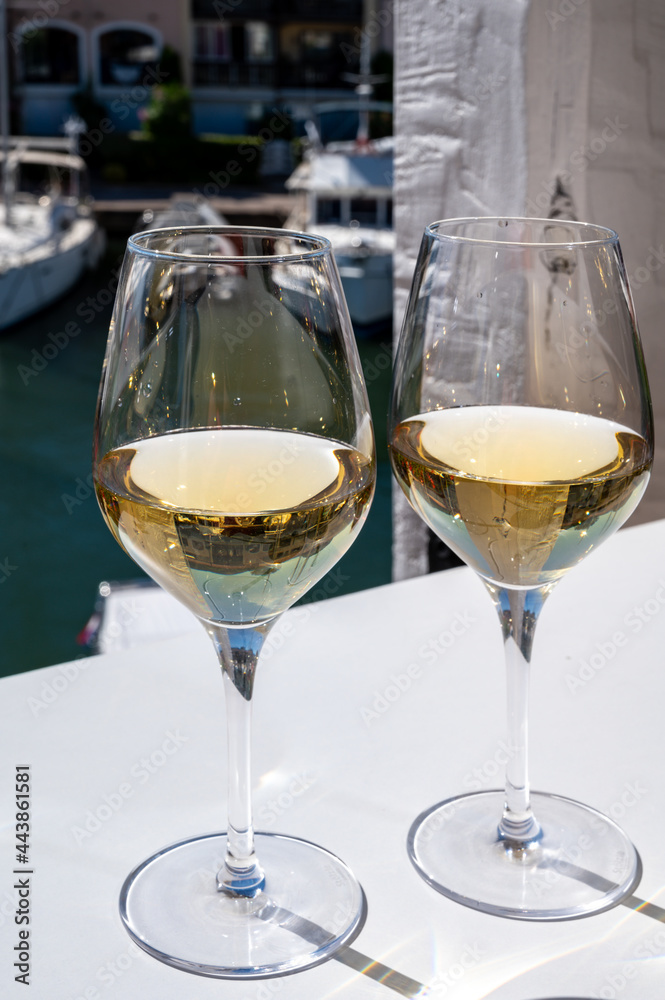 Summer on French Riviera Cote d'Azur, drinking cold dry white wine from Cotes de Provence on outdoor terrase in Port Grimaud, Var, France