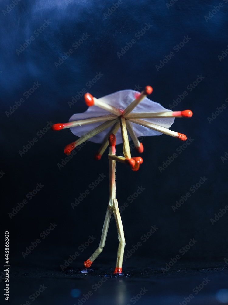 A matchstick man with a matchstick umbrella in the rain. Raining concept. Matchstick art photography used matchsticks to create the character. A matchstick man with a matchstick umbrella in the rain. Raining concept. Matchstick art photography used matchsticks to create the character.