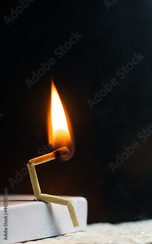 Concept of weakness, sadness, and loneliness. Image of a man-made matchstick. Burning matchstick man sitting alone without a partner. Matchstick art photography.