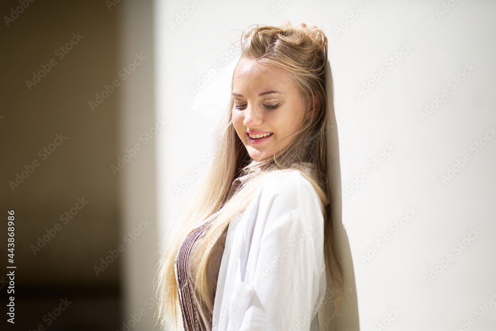 Fototapeta premium Portrait of young beautiful woman blonde hair standing against wall with copy space