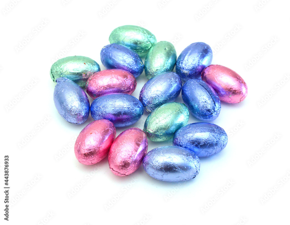 Chocolate easter eggs in colorful foil on white background Chocolate easter eggs in colorful foil on white background