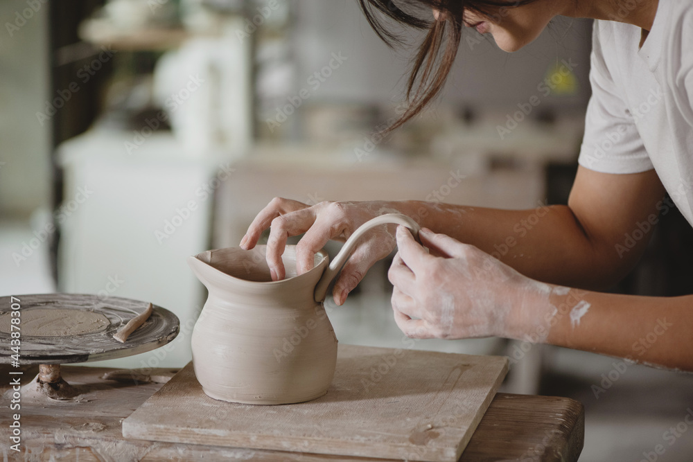 Young woman making pottery in studio. - obrazy, fototapety, plakaty 