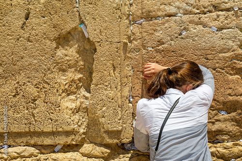 woman near Wailing Wall or Western Wall, in Islam as Buraq Wall was built from ancient limestone. It is relatively small segment of far longer ancient retaining