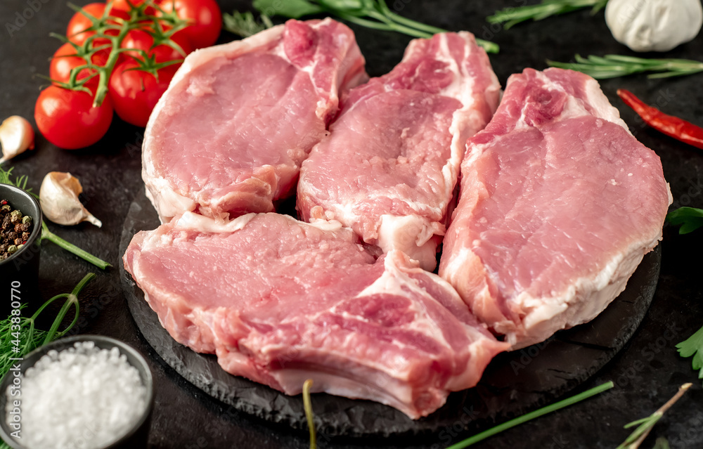 Raw pork steaks with ribs on stone background