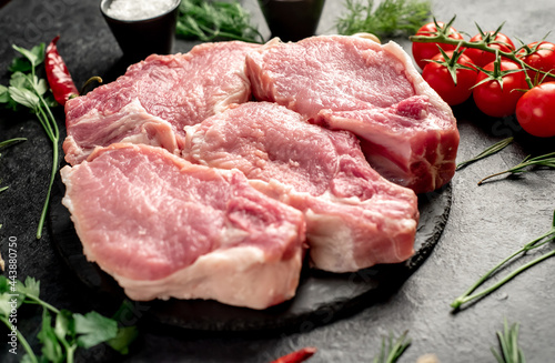 Raw pork steaks with ribs on stone background