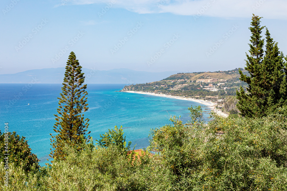 Beautiful views of the lush coastline of southern Italy with sandy beaches, blue skies and turquoise seawater. Tropea, Calabria, Italy.