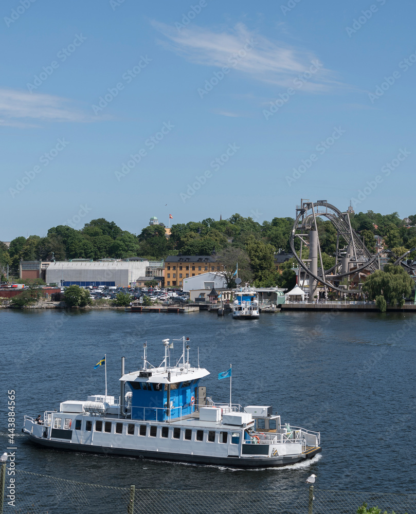 Modern commuting boat in the bay of the Stockholm harbor passing the amusement island Djurgården Modern commuting boat in the bay of the Stockholm harbor passing the amusement island Djurgården