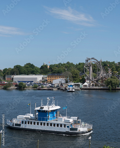 Photography Modern commuting boat in the bay of the Stockholm harbor passing the amusement i