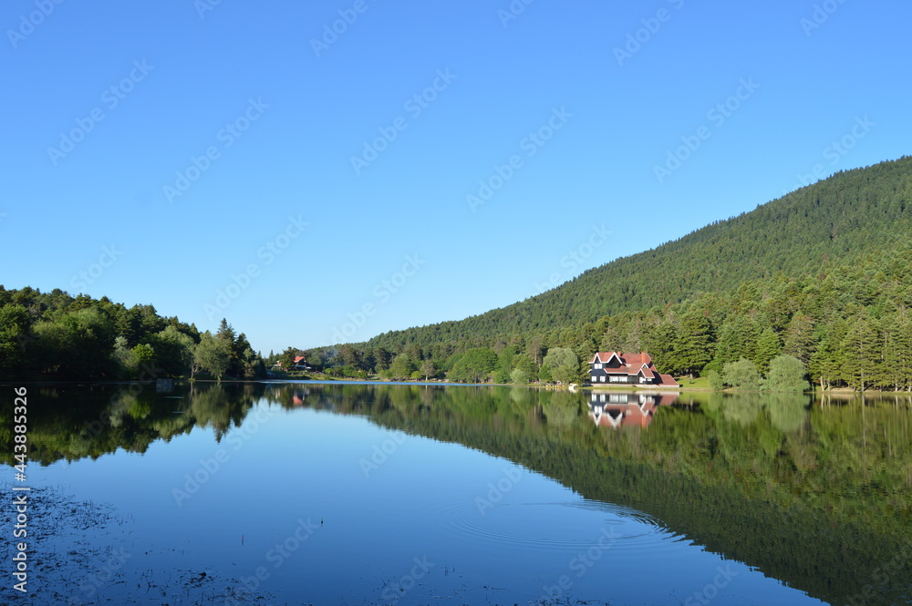 House on the lake in Bolu Gölcük National Park, reflection of trees and  house on lake