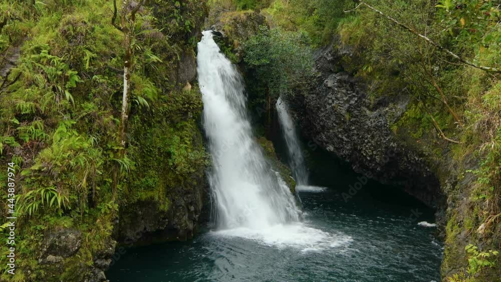 Tropical Waterfall - A waterfall, appears after a quick rain storm, flowing into a small crystal clear blue pond, inside of a dense rain-forest at side of the Road to Hana Highway, Maui, Hawaii, USA. Tropical Waterfall - A waterfall, appears after a quick rain storm, flowing into a small crystal clear blue pond, inside of a dense rain-forest at side of the Road to Hana Highway, Maui, Hawaii, USA.