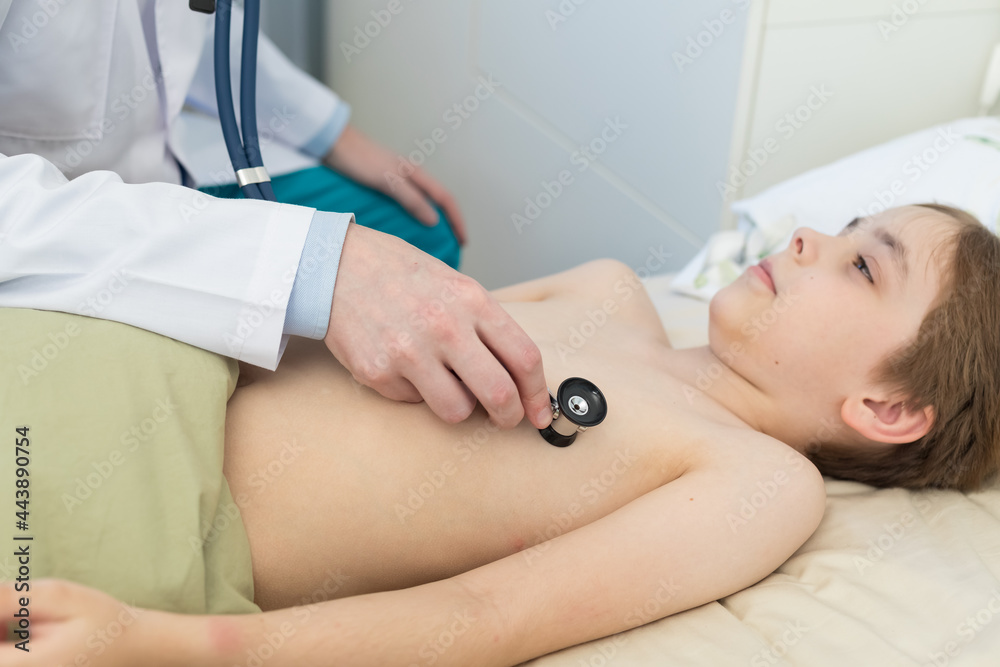 The pediatrician examines the child with a stethoscope. He checks the heart and lungs, listens to the body