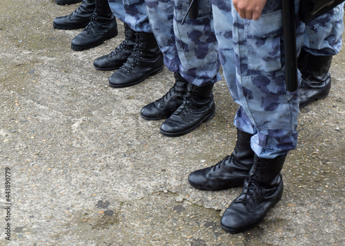Legs of the military in the ranks close-up. Polished military footwear. Camouflage uniform and boots.