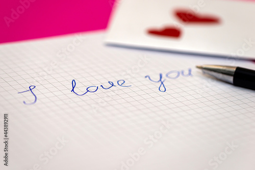 love letter, pen and envelote vith little paper hearts on pink background