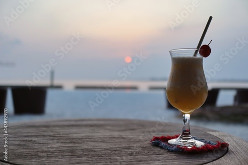 Fototapeta Naklejka Na Ścianę i Meble -  One Glass of Fruity Cocktail during Sunset in Maldives. Iced Beverage on Table in Maldivian Resort.