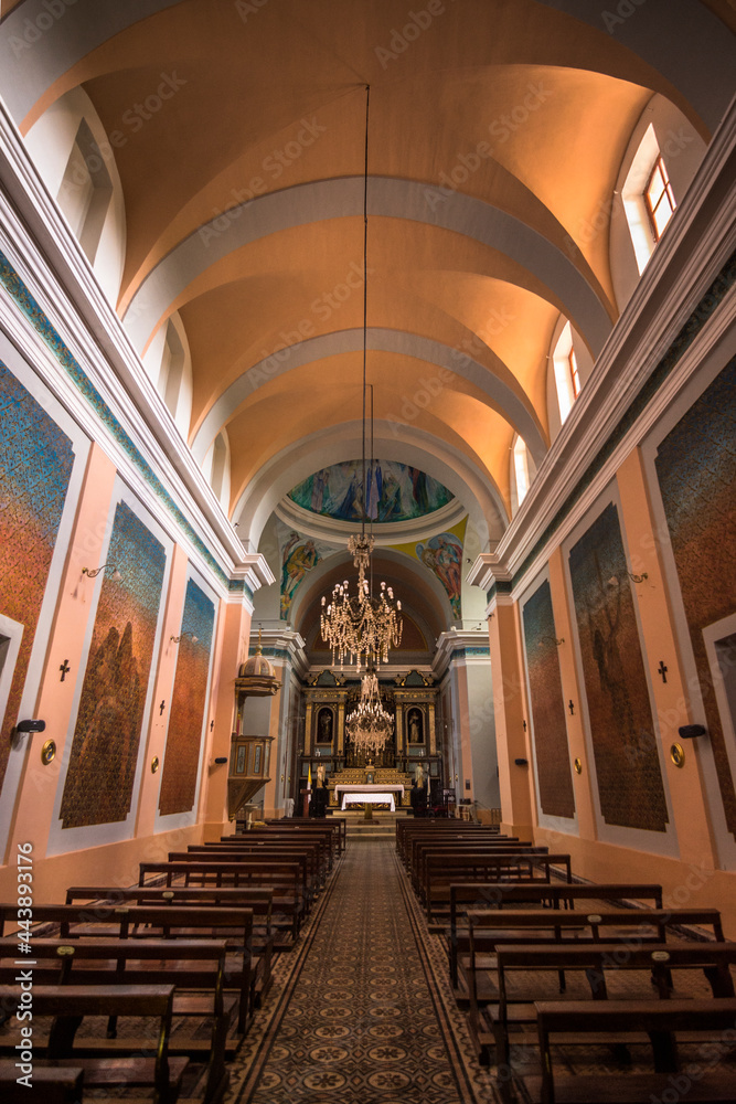 Fototapeta premium Symetric vertical view of the interior of a little historic chapel with dolourful paintings in Villa Tulumba, Córdoba, Argentina 