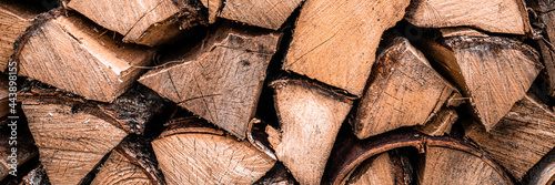 textured firewood background of chopped wood for kindling and heating the house. a woodpile with stacked firewood. the texture of the birch tree. banner