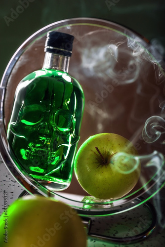 reflection of a green apple in a mirror with a green bottle in the shape of a human skull