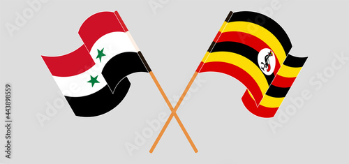 Crossed and waving flags of Syria and Uganda