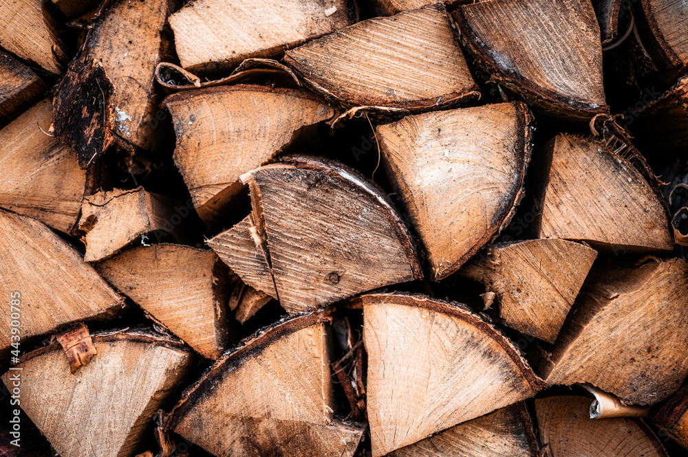 Fototapeta premium textured firewood background of chopped wood for kindling and heating the house. a woodpile with stacked firewood. the texture of the birch tree