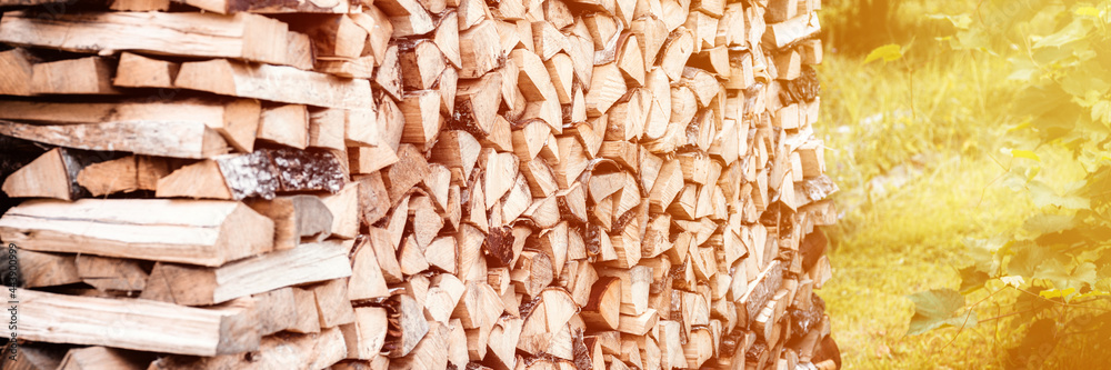 a woodpile with harvesting and stacked firewood of chopped wood for kindling and heating the house. firewood of the birch tree. banner.. flare a woodpile with harvesting and stacked firewood of chopped wood for kindling and heating the house. firewood of the birch tree. banner.. flare