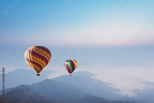 Hot air balloons flying over the mountain.