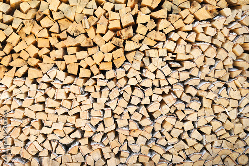 A lot of firewood stacked evenly, texture. Dry birch and pine for furnace. Logs background. Wooden birch logs, bonfire. Closeup, front view.