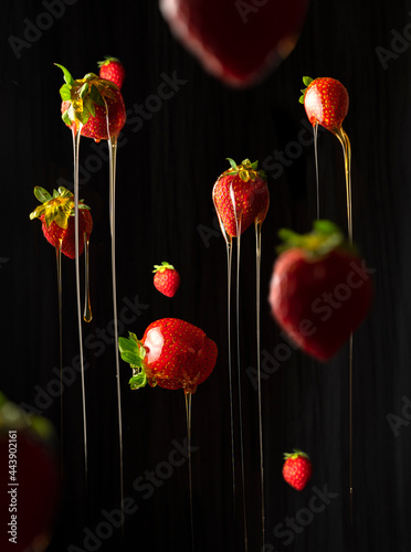 strawberries falling down and dripping with honey