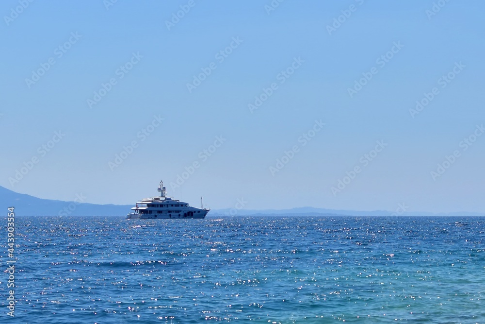 Ship in the sea. Marine yacht on the border of turquoise sea and blue sky on sunny day