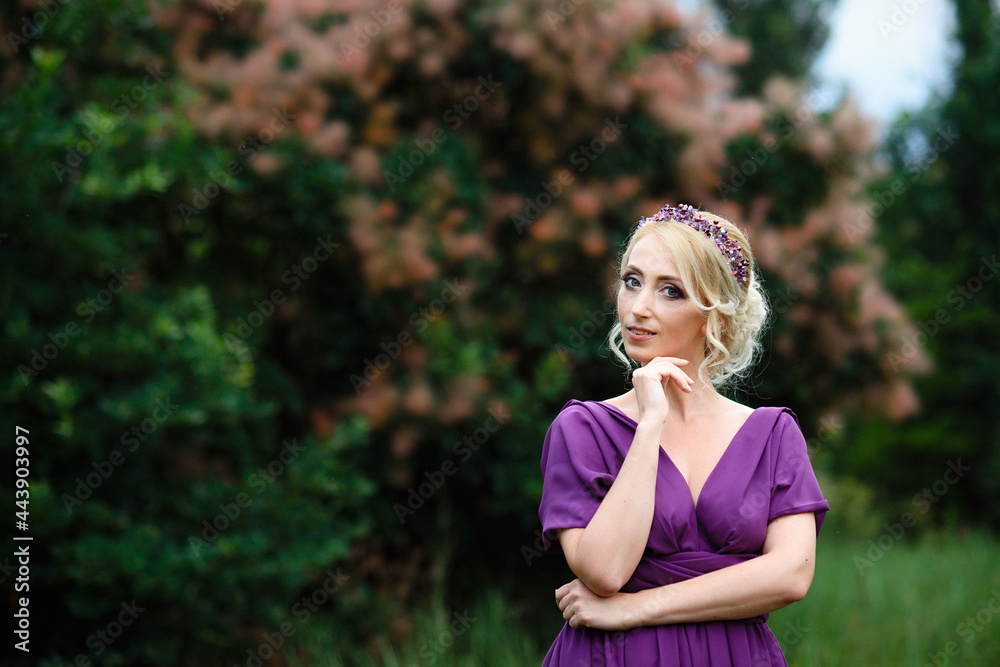 Girl model blonde in a lilac dress with a bouquet