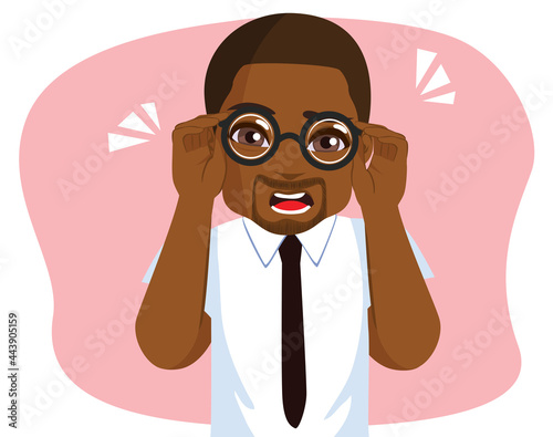 Black young man wearing white shirt and dark tie holding glasses trying to see better having vision problems