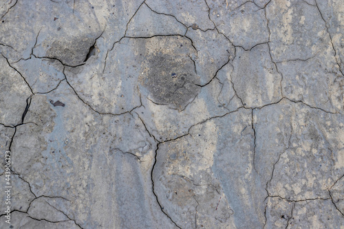 Fotografia, Obraz Close-up photo of the rough texture and gray color of the cracked earth in the a