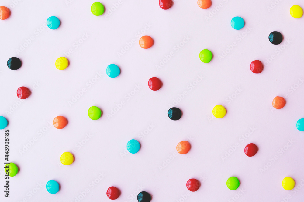 Colorful candies on a pink background
