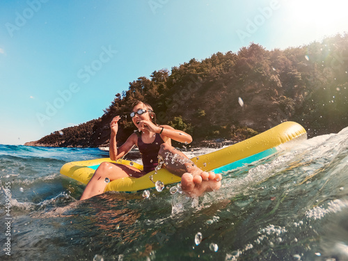Girl playing in the sea with air mattress