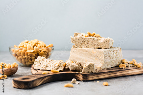 Pieces of sunflower and peanut halva on a cutting board on the table. Caloric oriental dessert photo
