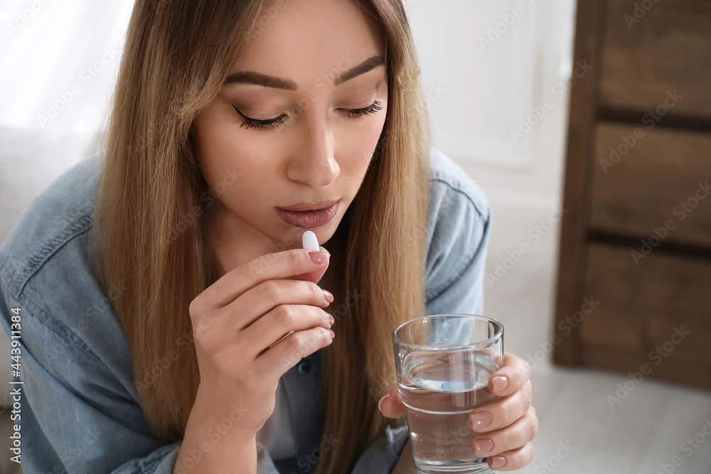 Young woman taking abortion pill at home Young woman taking abortion pill at home