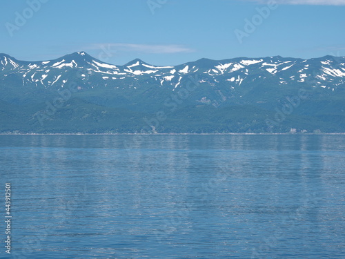 Hokkaido,Japan - June 22, 2021: Mountains in Shiretoko National Park viewed from Nemuro Strait, Shiretoko, Hokkaido, Japan, in summer
 photo